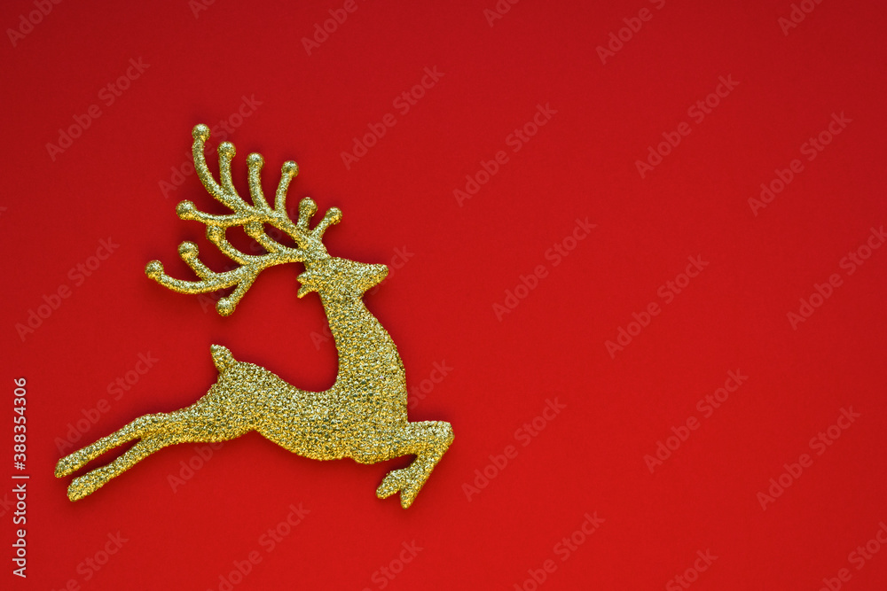 Naklejka premium Christmas card concept. Christmas golden toy deer on a red background