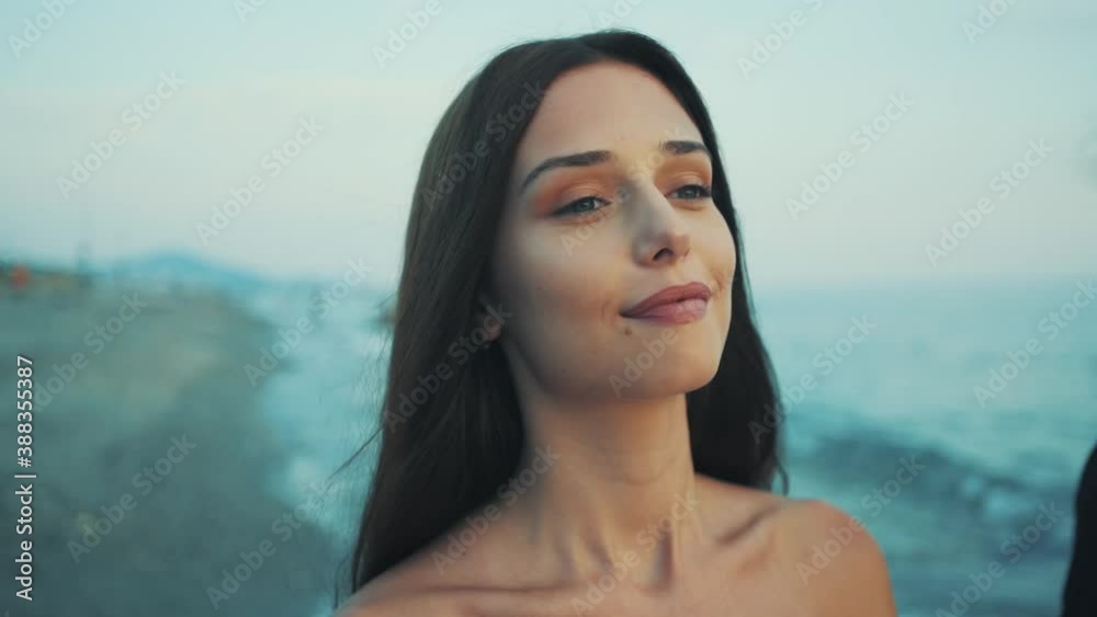 The camera captures the face of young girl walking on the beach at sunset. girl looking at her boyfriend with love. sunset love. The camera captures the face of young girl walking on the beach at sunset. girl looking at her boyfriend with love. sunset love.