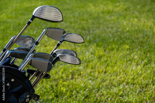 Golf sticks on green grass golf course, close up view.