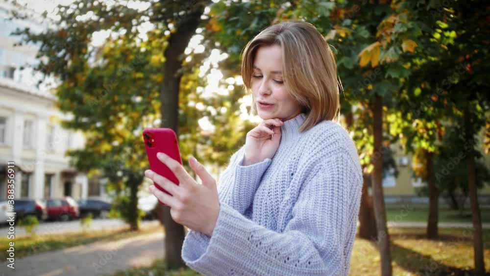 Happy girl having fun, making selfie photos on smartphone outdoor. Student using mobile applications for recording video.