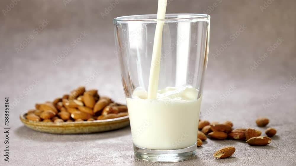 almond milk pouring in glass almond milk pouring in glass