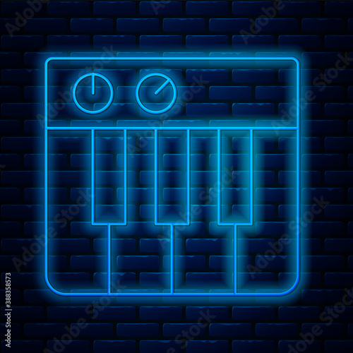 Glowing neon line Music synthesizer icon isolated on brick wall background. Electronic piano. Vector.