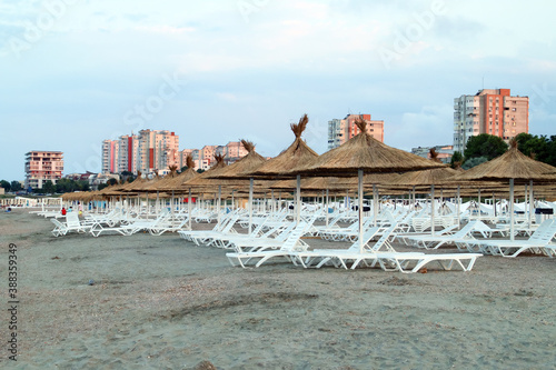 Sombrillas y tumbonas en una playa solitaria al atardecer. Playa tres zapatillas (rumano; Plaja trei papuci) en Constanta, Rumania. photo