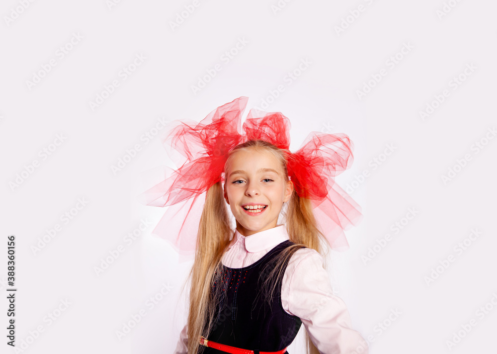 schoolgirl with bright tulle bows on her head in school clothes on a white background schoolgirl with bright tulle bows on her head in school clothes on a white background