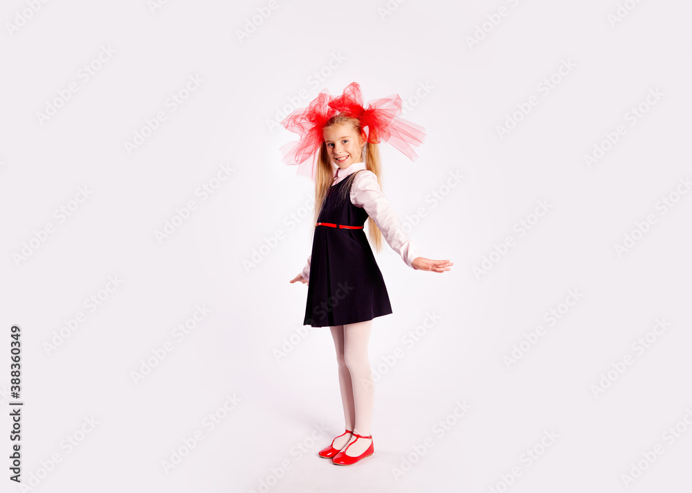 schoolgirl with bright tulle bows on her head in school clothes on a white background schoolgirl with bright tulle bows on her head in school clothes on a white background