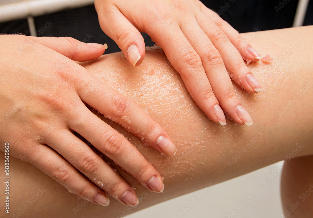 Largely hands girls massage the skin of their thighs with body scrub Largely hands girls massage the skin of their thighs with body scrub