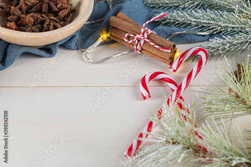 Bright Christmas or New Year wooden background with fir branches, Christmas decorations. Christmas sweets. Copy space. View from above