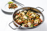 Wok with stir fry Udon noodles, seafood and vegetables. White background. Top view