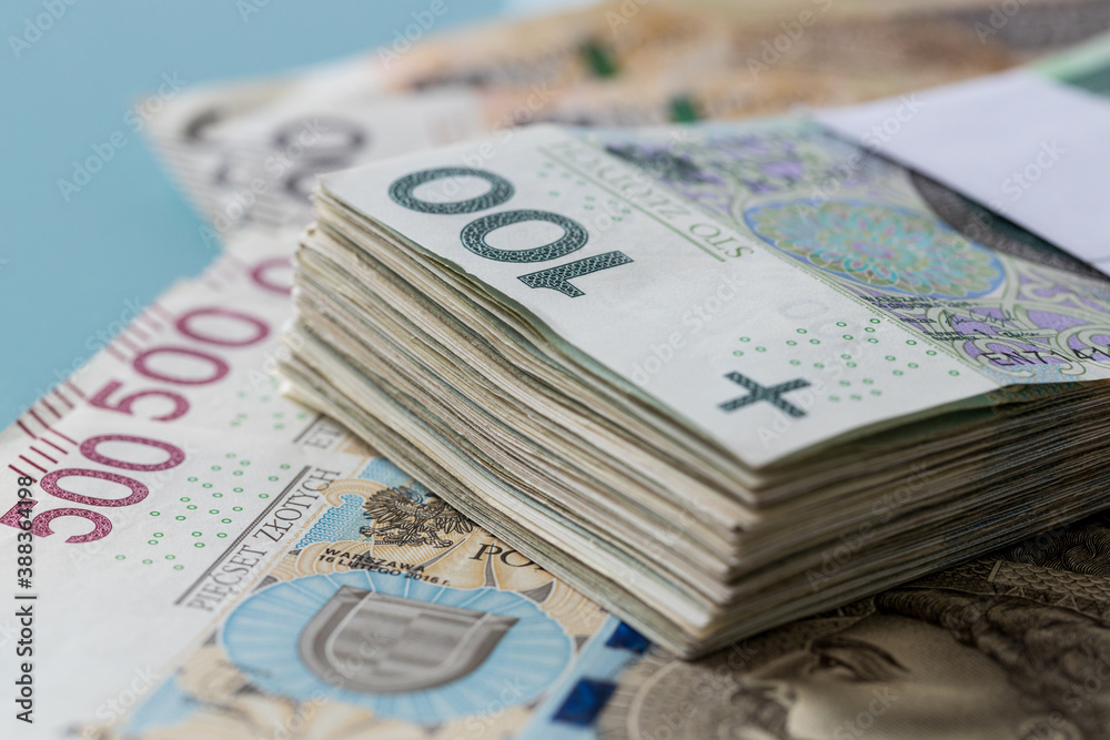 a file of Polish banknotes of one hundred zlotys fastened with a bank band lying on the money with the highest denomination five hundred zlotys a file of Polish banknotes of one hundred zlotys fastened with a bank band lying on the money with the highest denomination five hundred zlotys