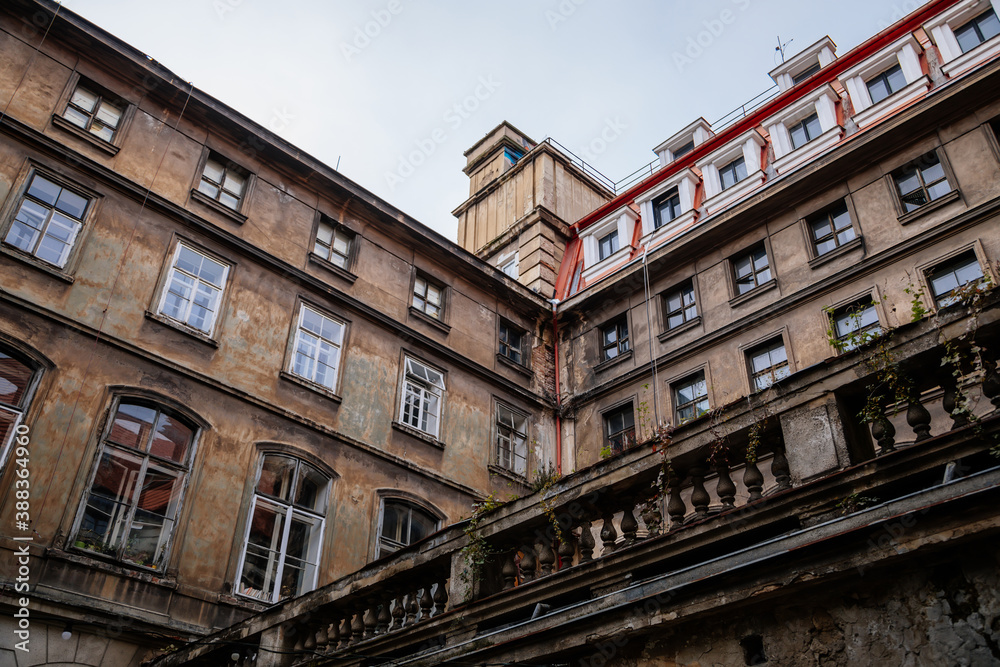 Сourtyard of old historical building of The College of Media and Journalism in the historic center during the autumn day, crumbling plaster and antique balcony in Prague, Czech Republic