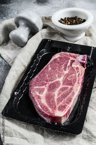 Fotografia Unopened vacuum pack of pork steak isolated on black background, without label