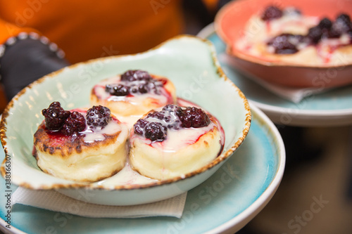 Freshly made cheesecakes lie on a plate covered with berry jam