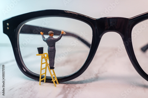 Фотография Tiny Figurine Cleans Eye Glasses