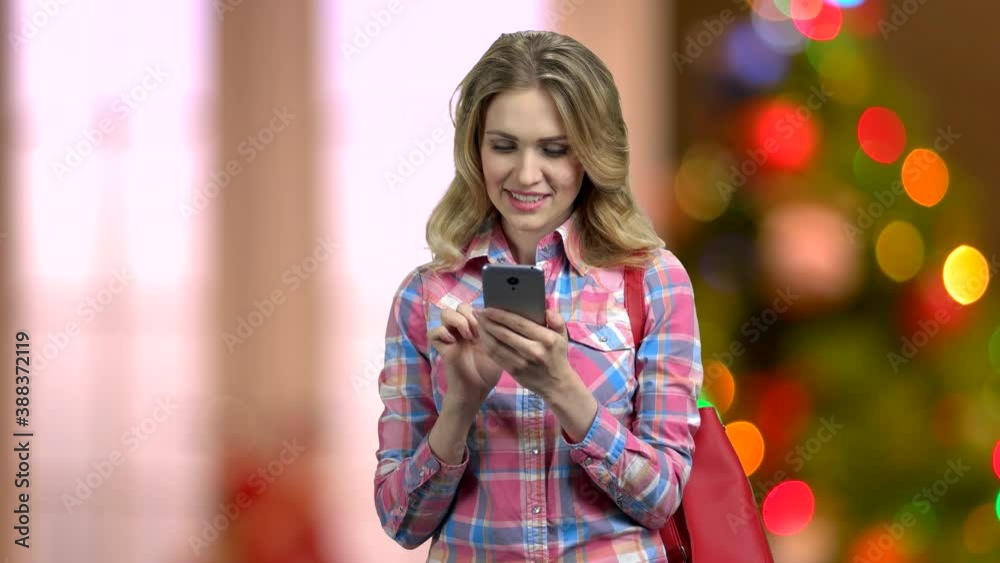 Woman using smartphone on abstract Christmas background. Happy winter holidays. Woman using smartphone on abstract Christmas background. Happy winter holidays.