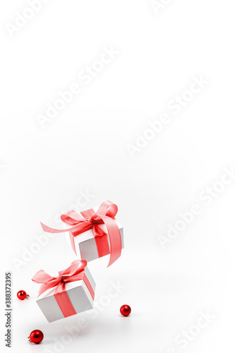 Winter sale. White gifts with red ribbon and New Year balls in xmas decoration on white background for greeting card. Christmas, winter, new year concept.