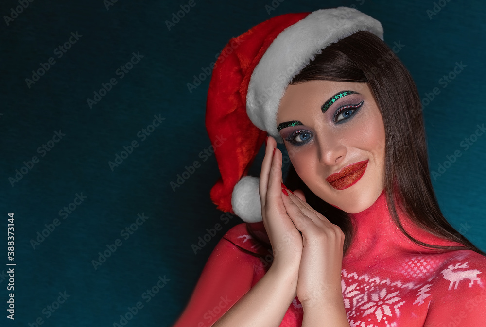 Beautiful brunette woman with creative art make-up wearing Santa Claus hat smiling at the camera Beautiful brunette woman with creative art make-up wearing Santa Claus hat smiling at the camera
