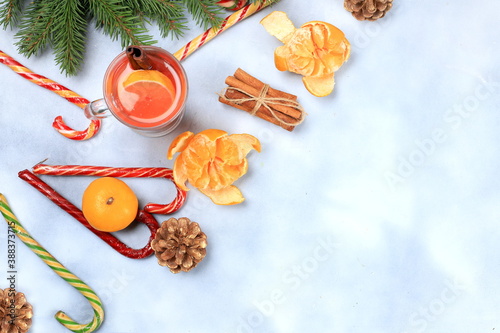 Christmas hot mulled wine or grog with lemon and cinnamon on the festive table. Winter composition with fir branches, tangerines, sweets, new year's background, diet and weight loss concept,