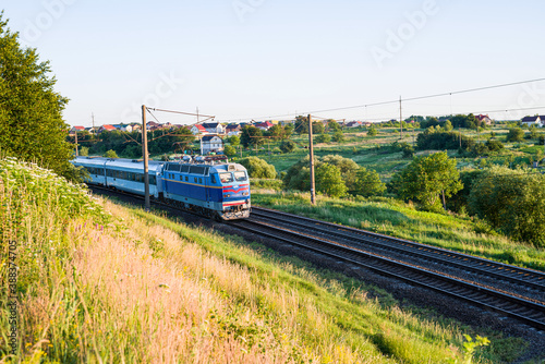 Passenger train with cars while moving on the railway