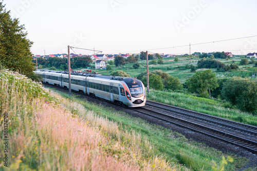 Passenger train with cars while moving on the railway