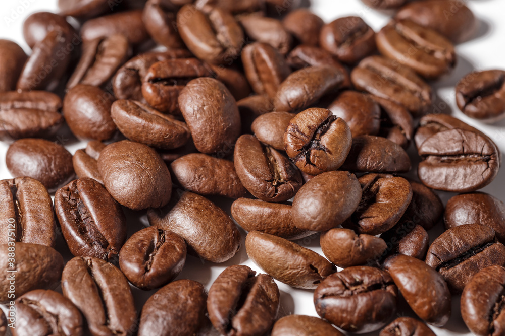 Obraz premium Freshly roasted coffee beans background.Dark roasted coffee beans with scoop on wooden background.