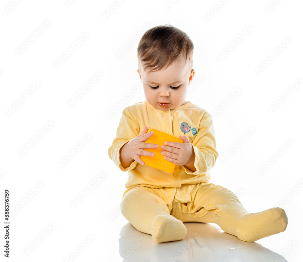 Baby in yellow shirt playing with bright blocks looking up in surprise Baby in yellow shirt playing with bright blocks looking up in surprise