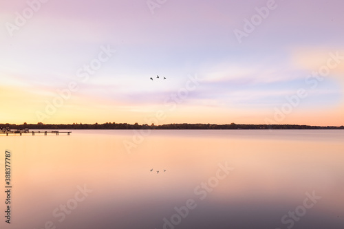 sunset over the lake, bird reflection in the water © Anita Gläßner