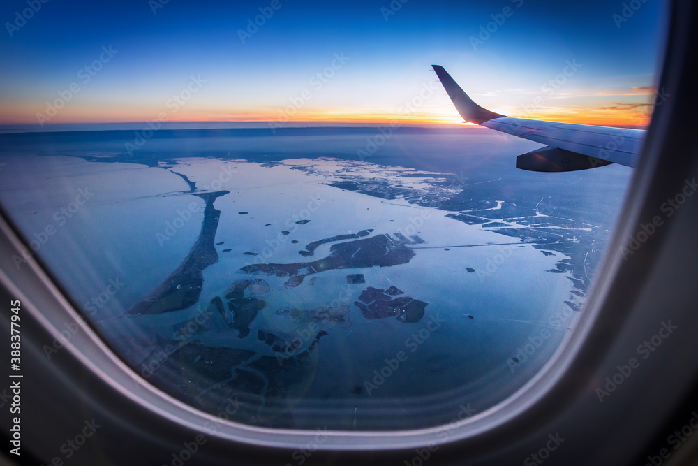 Aerial view of Venice from airplane window. View of Venezia and the Venetian Lagoon from the height of bird flight at sunset. Postcard view.