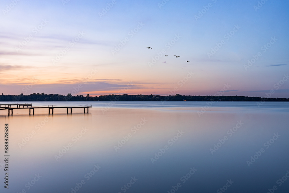 sunset and birds over the lake, footbridge in the lake 
