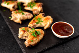grilled chicken wings with sauce on stone background. selective focus