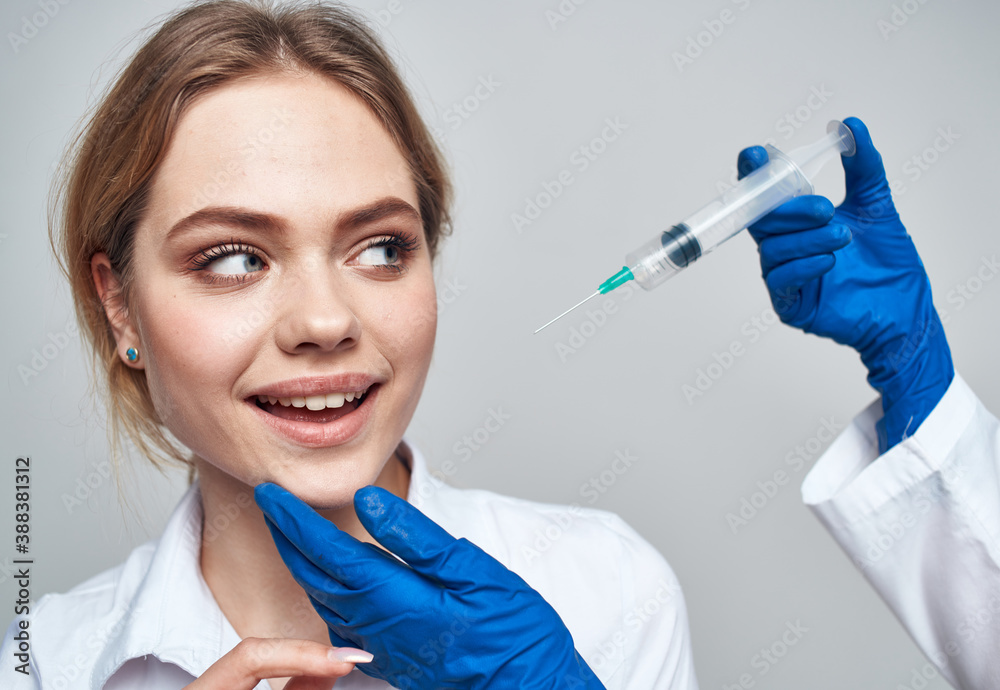 female patient smiling and a syringe in the hands of the doctor botox injection female patient smiling and a syringe in the hands of the doctor botox injection
