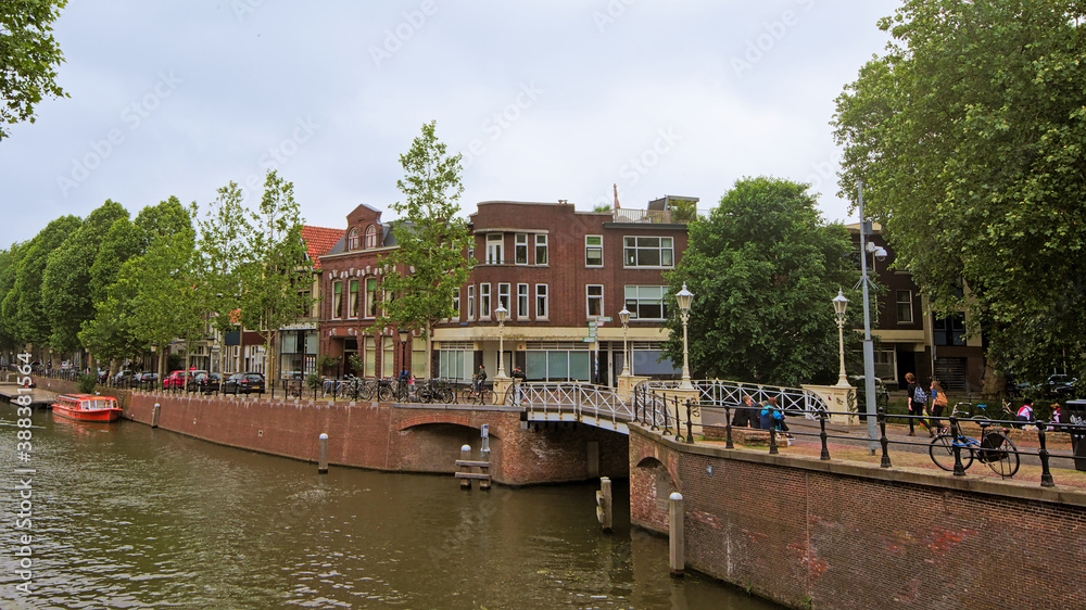Obraz premium Quays of `oudegracht` canal with typical brick stone houses and bridge in Utrecht, with traditional Dutch housess on a sunny day