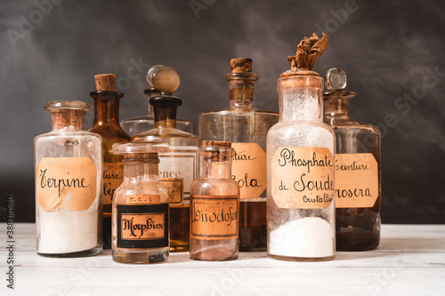 closeup of ancient apothecary pots with ingredients for medicine isolated over dark background 
