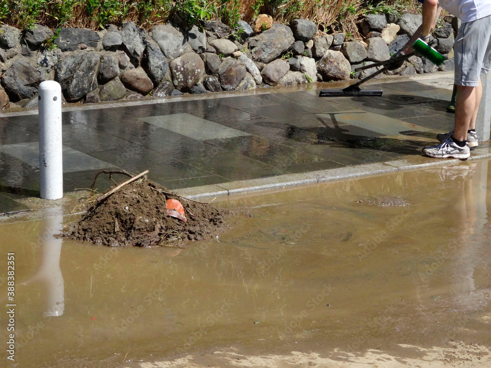 Naklejka premium 京都嵐山桂川の洪水で道路の泥を取り除く