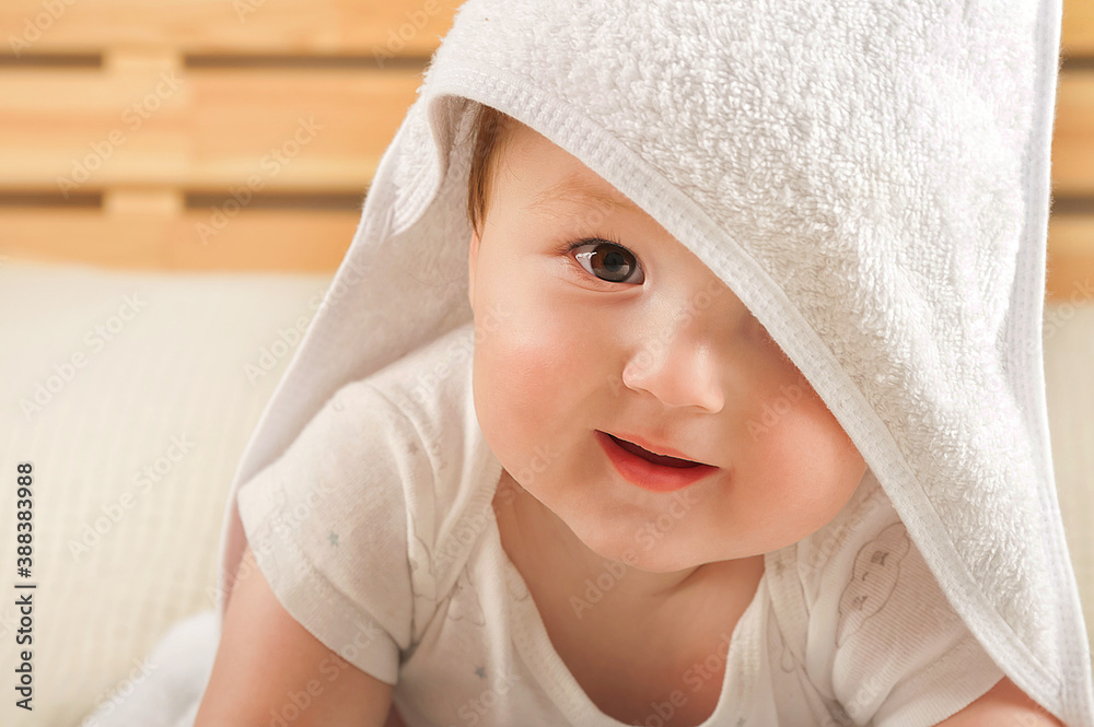 Beautiful little baby in a white towel on the bed close-up and copy space. Beautiful little baby in a white towel on the bed close-up and copy space.