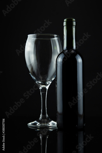 wine bottle and glass, black background 