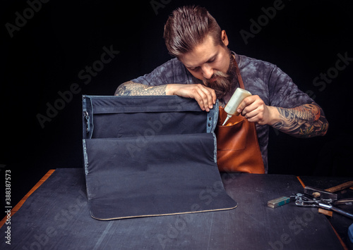 Artisan of leather manufacturing new leather product at the place of work photo