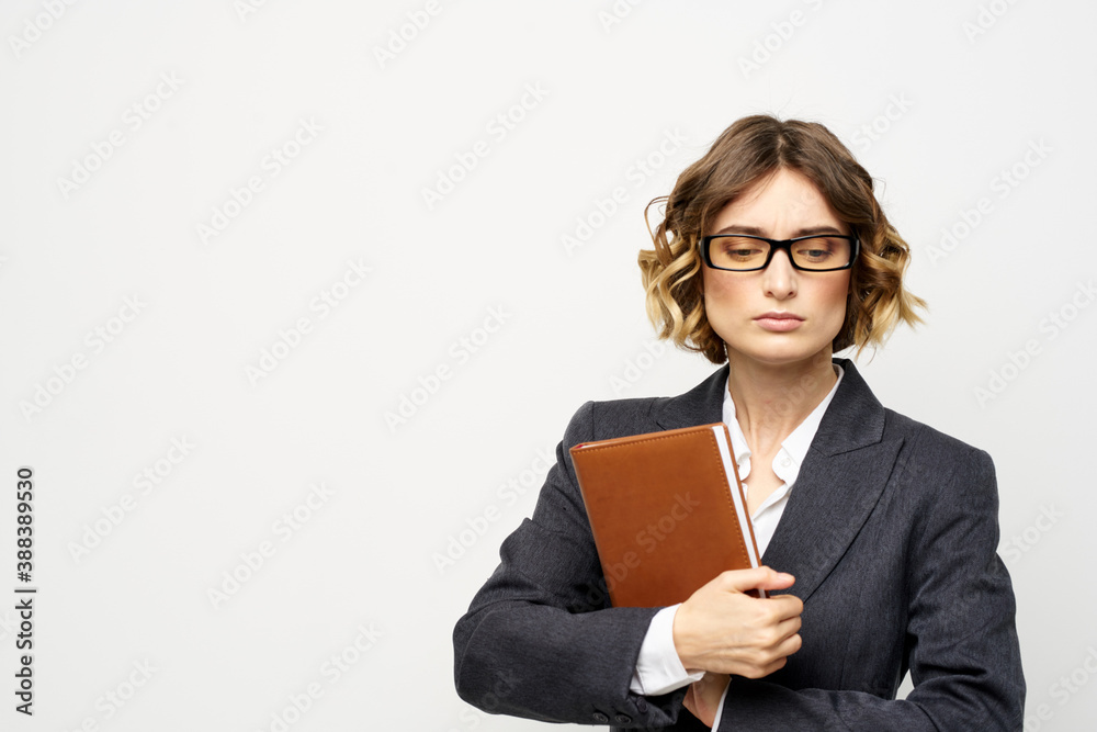 Business woman with notepad and glasses work light background cropped view of suit model. Business woman with notepad and glasses work light background cropped view of suit model.