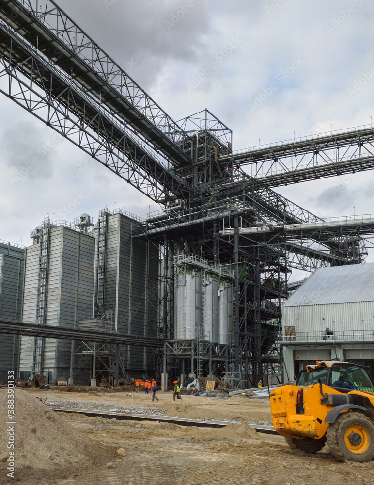 Construction process of grain elevator. Agro manufacturing plant for processing drying cleaning and storage of agricultural products, flour, cereals and grain. Granary elevator.