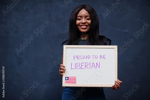 Proud to be liberian. Fashionable african woman hold board with Liberia flag.