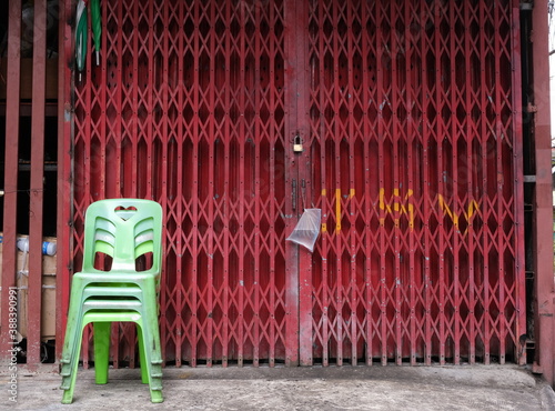 Plastic chairs stacked in front of metallic gate © iFocus