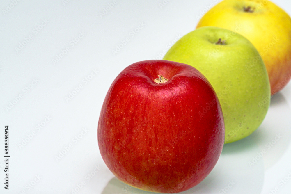 Three juicy ripe apples on a white background, close-up view. Three juicy ripe apples on a white background, close-up view.