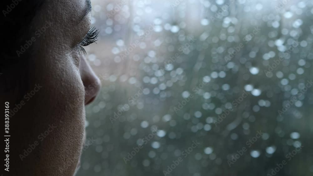 sadness, depression - pensive woman looks out the window in a rainy day - macro
