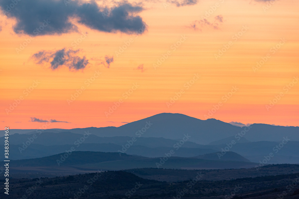 Fototapeta premium Landscape sunset colors over mountains and hills orange red yellow blue shades natural beauty bulgaria rural