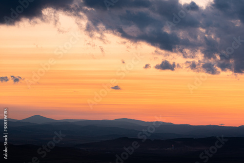Landscape sunset colors over mountains and hills orange red yellow blue shades natural beauty bulgaria rural © Valentin