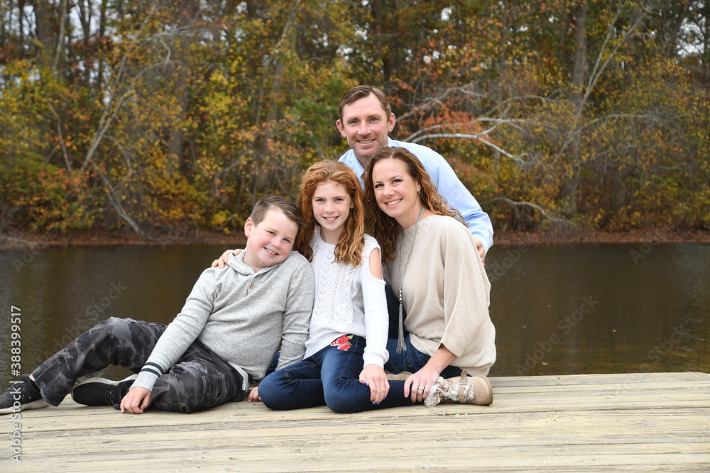 Autumn family portrait by the lake with mom, dad, son and daughter. Autumn family portrait by the lake with mom, dad, son and daughter.