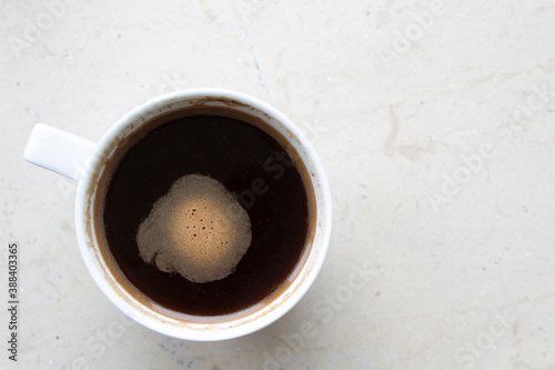 Top view white cup with black americano coffee drink on light table surface 