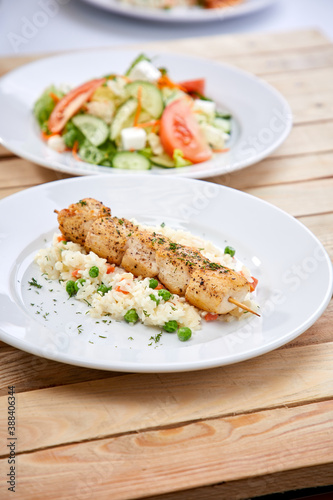 chicken kebab with rice and salad on the wooden background