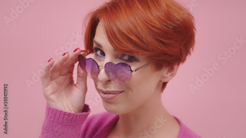 Portrait of beautiful middle aged red head woman with heart shaped glasses. Beauty shot. High quality photo