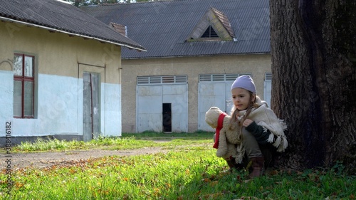 Mistreated child. Little girl with teddy bear is scared. Child in danger.