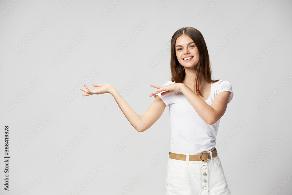 Happy woman in white t-shirt shows hands to the side and smiles Copy Space Happy woman in white t-shirt shows hands to the side and smiles Copy Space